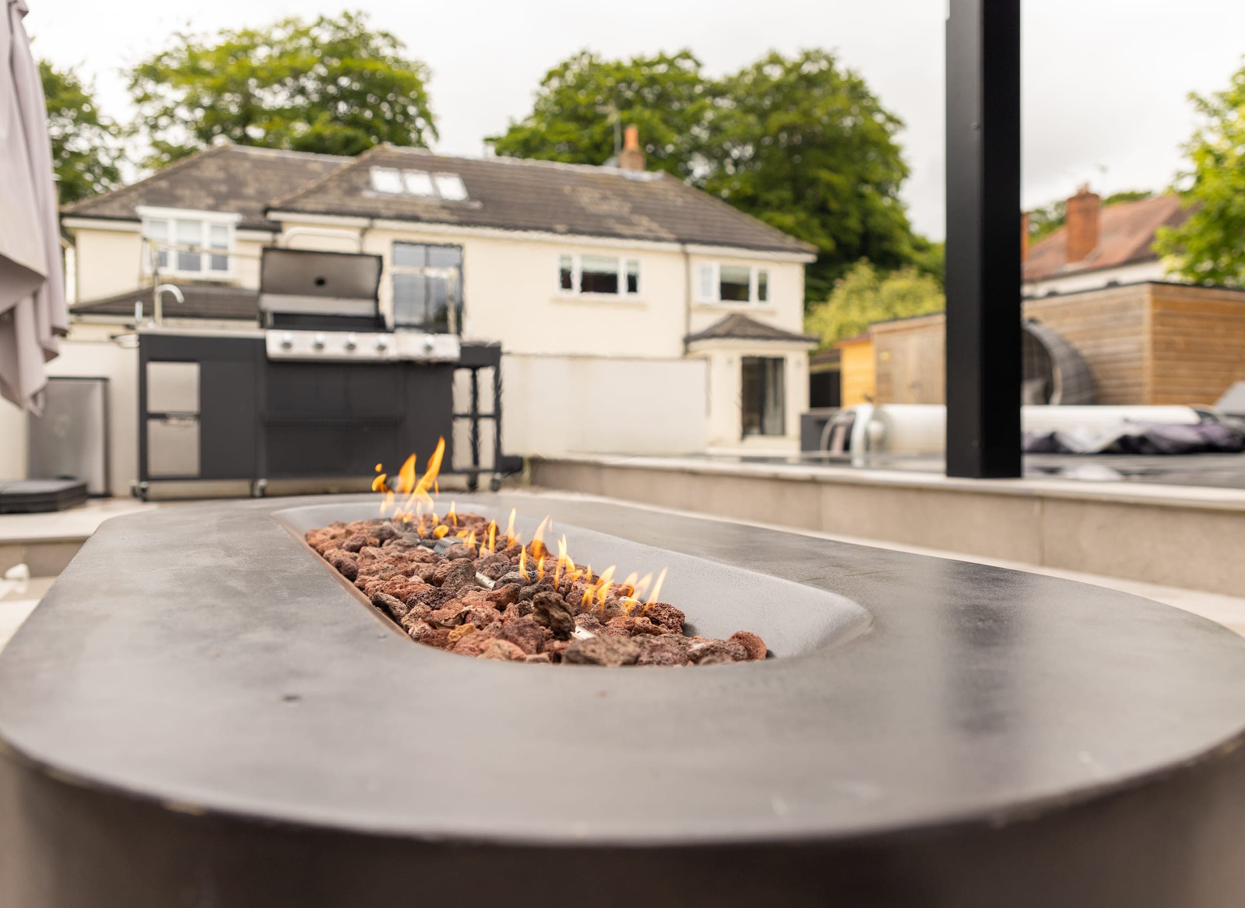 A fire table burning on the terrace at the back of the house
